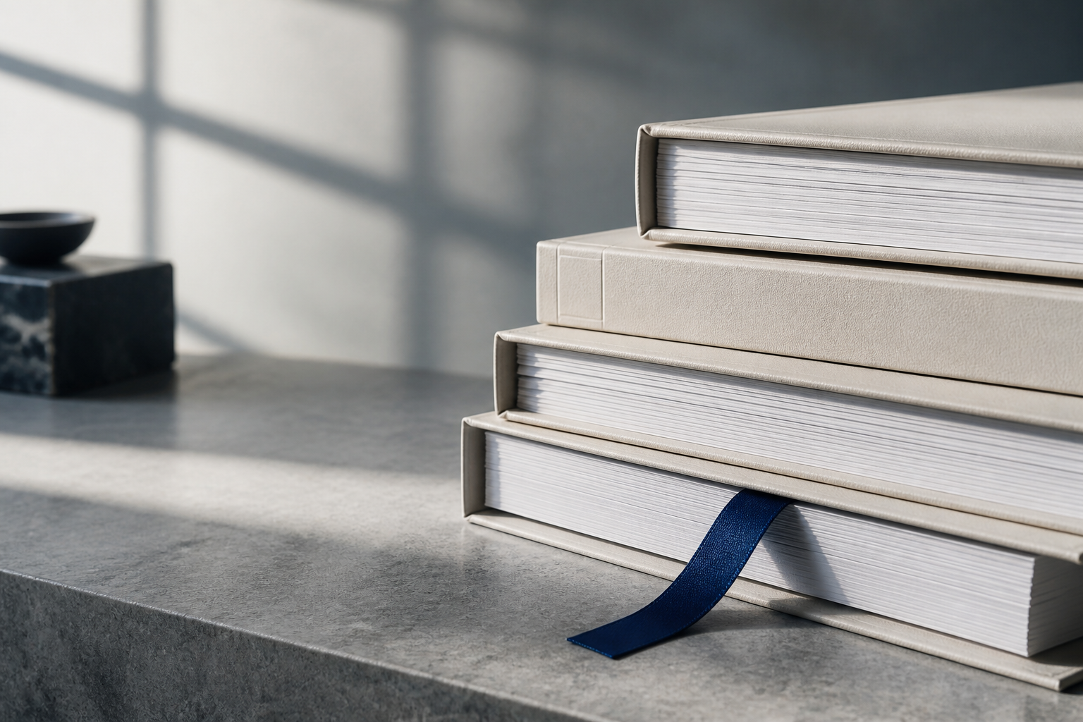 Stacked valuation reports on a stone surface with a cobalt ribbon bookmark.
